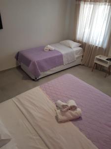 a bedroom with two beds with towels on the floor at Amaya Pine Rooms in Keramoti