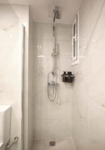 a white bathroom with a shower and a sink at "Under the olive tree"- Beautiful apartment in the heart of Athens in Athens