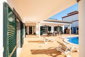 a villa with a swimming pool and a patio at Villa Isa - Heated Pool - Free wi-fi - Air Con in Guia