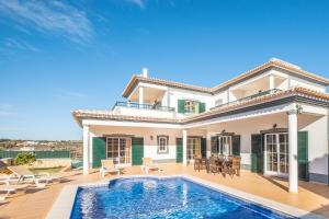 uma villa com uma piscina e uma casa em Villa Isa - Heated Pool - Free wi-fi - Air Con na Guia