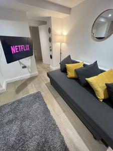 a living room with a couch and a television at The Windsor Apartment by GGE, Brighton Beach, Sleeps 4 in Brighton & Hove