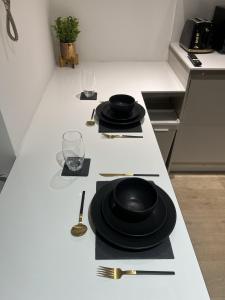 a kitchen counter with black plates and utensils on it at The Windsor Apartment by GGE, Brighton Beach, Sleeps 4 in Brighton & Hove