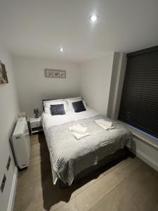 a bedroom with a bed with two towels on it at The Windsor Apartment by GGE, Brighton Beach, Sleeps 4 in Brighton & Hove