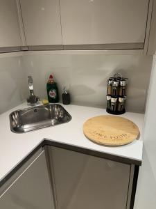 a kitchen counter with a sink and a wooden cutting board at The Windsor Apartment by GGE, Brighton Beach, Sleeps 4 in Brighton & Hove
