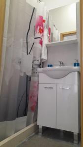 La salle de bains est pourvue d'un lavabo blanc et d'un miroir. dans l'établissement Ellamar City Center Apartment 2, à Makarska