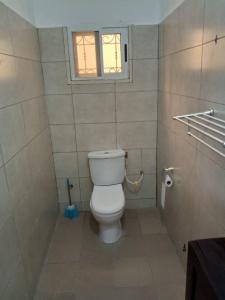 a bathroom with a white toilet with a window at Sweet home 