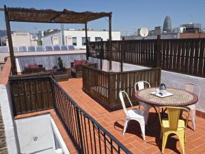 a patio with a table and chairs on a roof at Sunny Rooftop Apartment in Barcelona