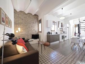uma sala de estar com um sofá e uma cozinha em Sunny Rooftop Apartment em Barcelona