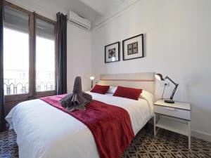 a white bedroom with a large bed with red pillows at Sunny Rooftop Apartment in Barcelona