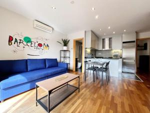 een woonkamer met een blauwe bank en een tafel bij Teatro Miro Apartment in Barcelona