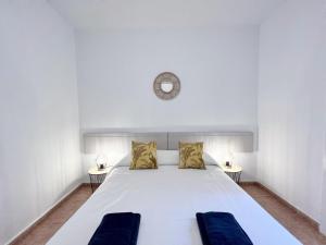 sypialnia z białym łóżkiem i zegarem na ścianie w obiekcie Villa Olimpica Beach w Barcelonie