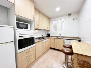 - une cuisine avec des appareils blancs et des armoires en bois dans l'établissement Villa Olimpica Beach, à Barcelone