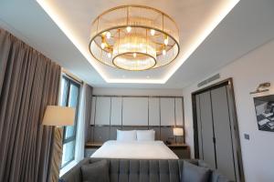 GimpoにあるHotel Marinabay Seoul Araのベッドとシャンデリアが備わるホテルルームです。
