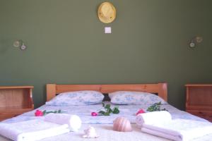 1 dormitorio con 2 camas, toallas y reloj en la pared en Melina Apartment, en Loutrópolis Thermís