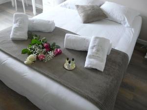 - un lit avec un plateau de fleurs et 2 serviettes dans l'établissement Orée de Marmeloux, à Sainte-Catherine
