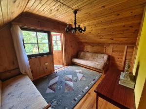 um quarto com um sofá e uma janela numa cabina em Białka Domek Nad Jeziorem em Białka