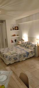 a bedroom with a bed and two lamps and a table at Casa GiuLy' in Leporano