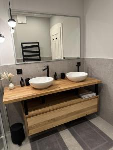 ein Badezimmer mit zwei Waschbecken auf einer Holztheke mit einem Spiegel in der Unterkunft Ferienwohnung Sommer - mit privatem Seezugang in Seeboden