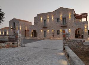 a large stone building with lights on it at Terra Di Pietra Exclusive Suites & Apartments in Areopolis
