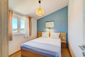 a bedroom with a bed with a blue wall at MT SUN 115 App 1 in Selce