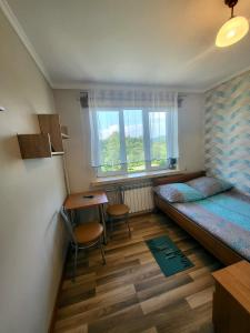 um quarto com 2 camas, uma mesa e uma secretária em Nad Jeziorem Domki i Pokoje 781-281-434 em Polańczyk
