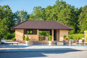 una casa con piscina frente a ella en Apartments Lucija en Slunj