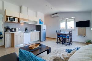 a living room with a couch and a kitchen with a table at MT SUN 115 App 1 in Selce