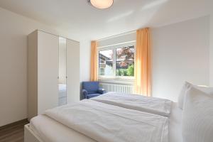 シュヴァンガウにあるFerienwohnung Philomenaの白いベッドルーム(ベッド1台、青い椅子付)