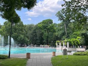 a fountain in a park with people walking around it at 7Mins City Garden and Center+P in Plovdiv