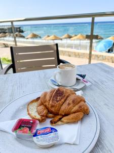 a plate with a breakfast of croissant and a cup of coffee at Perla Marina in Nerja