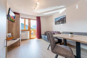 a living room and dining room with a table and chairs at MOUNTAIN RESIDENCE ALPENHOF - company Hotel Alpenhof KG sas der Gasser Renate in Bressanone