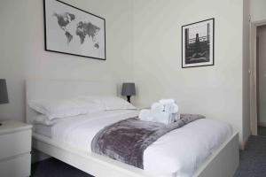 a bedroom with a white bed with towels on it at Stunning 2 bed apartment with sea views, Penzance in Penzance