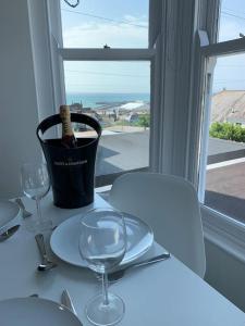 - une table avec une bouteille de vin et deux verres dans l'établissement Stunning 2 bed apartment with sea views, Penzance, à Penzance