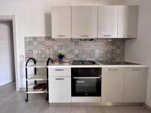 a kitchen with white cabinets and a stove at Villa Eleonora in Palmi +59 photos