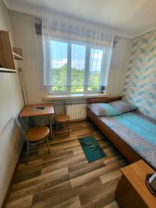 um quarto com uma cama, uma secretária e uma janela em Nad Jeziorem Domki i Pokoje 781-281-434 em Polańczyk