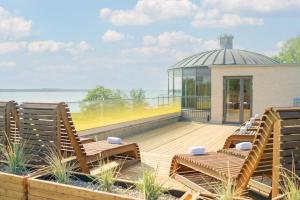 a deck with chairs and a gazebo at Appartements "Zum Leuchtturm" Hafen Rankwitz Insel Usedom in Rankwitz