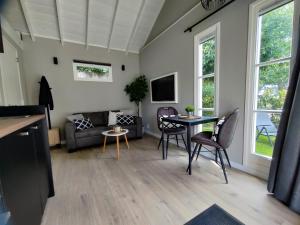 a living room with a couch and a table and chairs at Park De Driesprong in Nieuwveen