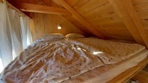 ein großes Bett in einem Zimmer mit Holzdecke in der Unterkunft Pig barn - Svinjaki 