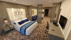 AlHamra Hotel Kuwait في الكويت: غرفة نوم مع سرير وغرفة معيشة