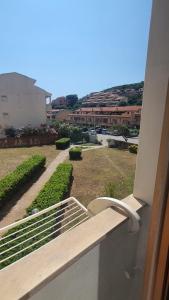 un balcon avec vue sur un champ et des bâtiments dans l'établissement palau casa vacanza le ginestre, à Palau