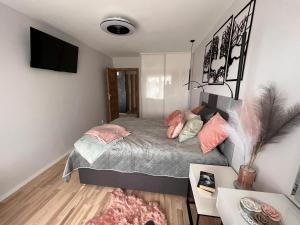 um quarto com uma cama com almofadas cor-de-rosa em Apartament Pod Dmuchawcem em Dziwnów