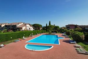 a large swimming pool with lounge chairs around it at Appartamento Al Cascinale in Desenzano del Garda