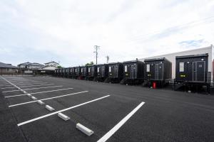 a row of train cars parked in a parking lot at HOTEL R9 The Yard Iwakuni in Iwakuni