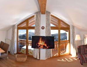 een woonkamer met een open haard en een groot raam bij Haus Sonnbichl in Schliersee