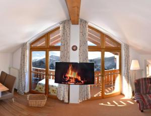 a living room with a fireplace and a large window at Haus Sonnbichl in Schliersee