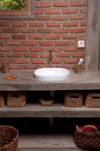 umywalka w łazience przed ścianą z cegły w obiekcie Master bed room inBukit Cottage Pak Ansel 