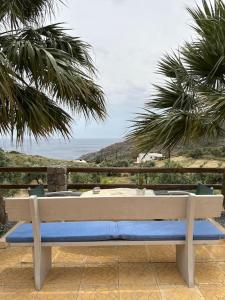 un banco sentado en un patio con vistas al océano en Souda’s nest en Plakiás
