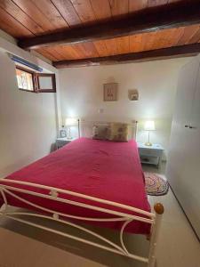 1 dormitorio con 1 cama con manta roja en Souda’s nest en Plakiás