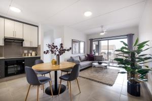 a kitchen and living room with a table and chairs at Ballito Village Luxury Apartments in Ballito