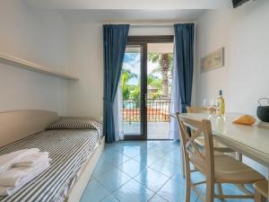 1 dormitorio con cama, mesa y comedor en Green Village Resort en Villasimius